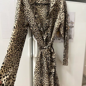 Leopard omlott klänning - Säljer denna super fina leopard omlott klänningen med band rund midjan, i storlek M. Men skulle säga att den är mer åt S/liten M.  Nyskick!  Möts upp i Helsingborg men skickar även spårbart. 