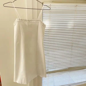 Vit klänning - Klänning från Urban Outfitters, avklippt kant nertill och fodring på insidan. Den ser lite vaniljvit ut på bilderna men är helt kritvit i verkligheten Var tänkt som studentklänning men blev aldrig så och har bara använts 1 gång!