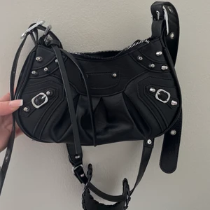 EJ SÅLD! Nyskick - På grund av oseriöst budgivare så finns väskan kvar! Axelremsväska med detaljer, nyskick. Väldigt rymlig och passar till det mesta. Köp direkt för 250kr