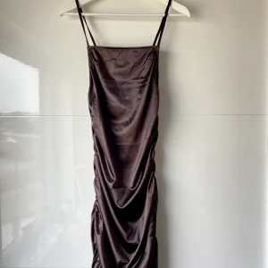 Brun klänning - Säljer denna snygga silkes imiterade klänningen. Använd endast 1 gång och är som ny!! Storlek M men skulle säga att den passar en S också då jag varierar mellan storlekarna. Köparen står för frakt 💕
