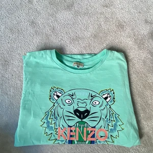 Kenzo t shirt - Kenzo t shirt i färgen turkos, fick den i födelsedagspresent för ungeför 2 år sen. Den är köpt på NK barnavdelningen för 650 kr, i storleken 14A/164!! T shirten är i nyskick och inte använd på ett tag, sparsamt använd! 💚💚🦋