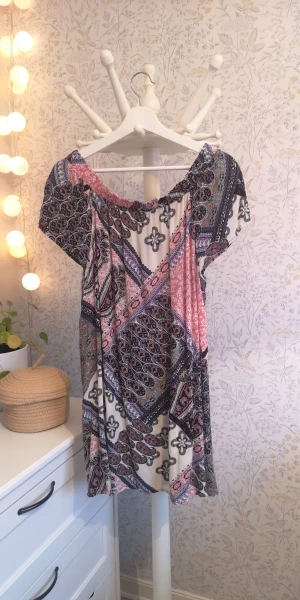 Klänning/Tunika  - Klänning/Tunika i ett fint tyg med mycket mönster. Klänningen är en off shoulder modell. Storlek M. 