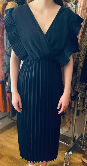 Skön veckad klänning - Lång och luftig veckad klänning i marinblå. Kan ha som den är eller med en vit blus under. 