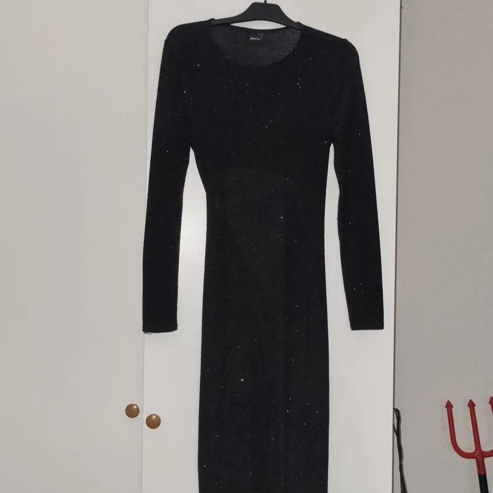 En glittrig lång klänning där ryggen är öppen vid svanken. Använd 1 gång. Köparen står för frakt (99kr). Klänningar.