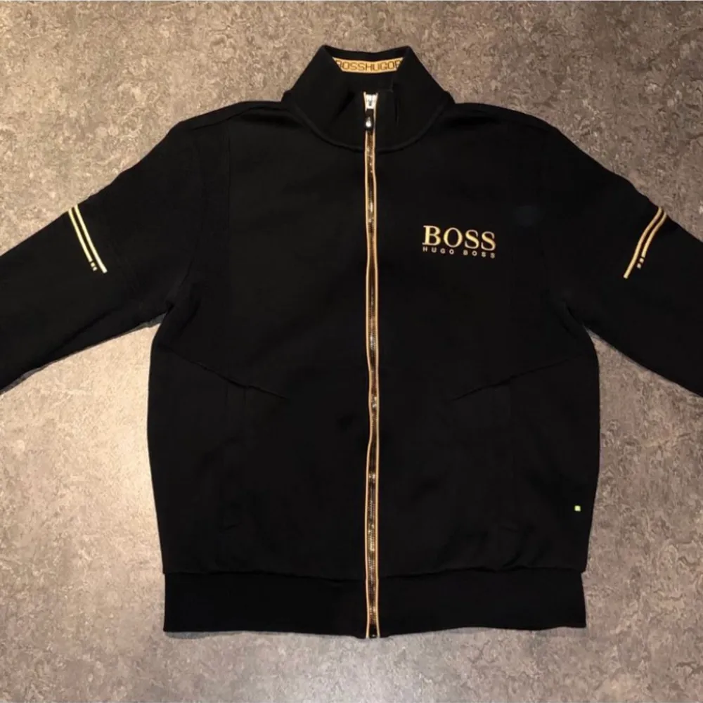 Guld svart boss tröja nyskick. Tror inte den säljs längre heller. Ny pris 2000 mitt pris 900. Regular fit men passar typ 165-173 cm.. Hupparit & Collegepaidat.
