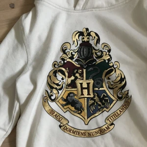 Hoddie-Harry potter X HM - Vit hoodie med Harry potter märke på. Lite knopprig, är kanske 2 år gammal. 