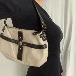 liten beige och brun axelväska  - assöt beige axelväska med bruna remmar och en ring<3 köpt second hand, fint skick och i fuskskinn. skriv för mått eller frågor ﾐ☆