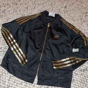 Retro Adidas jacka - Retro Adidas Orignials jacka i nyskick, endast dragsko i nedre delen saknas, lätt åtgärdat, annars i topp och passar som både jacka & tröja.   Kan mötas upp i Stockholm eller skicka om köparen betalar frakt