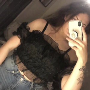 Svart topp - En svart topp med lite fluffiga armar från NA-KD. Aldrig andvänd och prislappen sitter kvar🥰