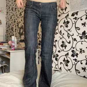 lågmidjade svarta/mörkgrå jeans med detaljer på fickorna 