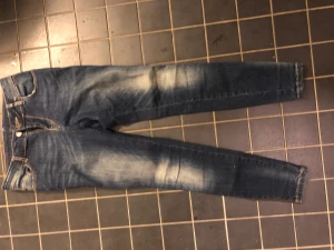 Jeans  - mörkare jenas från lager 157 med slitningar och halv hög midja. smala ben med dragkedja längst ner. ger en super siluett och snygg rumpa. 