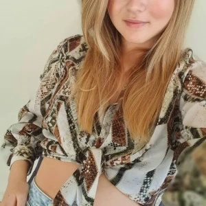 Mönstrad blus  - Långärmad blus i blankt tyg. Knappar framtil. Nyskick 