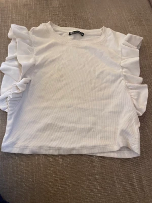 vit volangtopp  - säljer vit urgullig volangtopp ifrån zara! super söt och passar till allt men klär ändå upp outfiten med volanger! köptes för ca 100kr för ett år sedan men säljs för 45kr+frakt!🤍