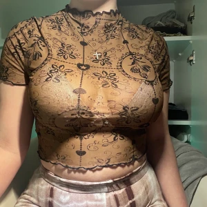 Ljusbrun top med svarta konturer. - Säljer min fina topp från shein då den inte kommer till användning mer. Den är lite genomskinlig i ljuset. Den sitter bra och inte för tajt. Köpte den för lite drygt ett år sedan men är nästan oanvänd. 