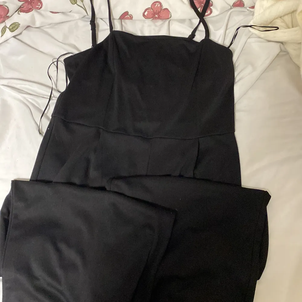 En fin svart jumpsuit i storlek L säljs för 100kr . Klänningar.