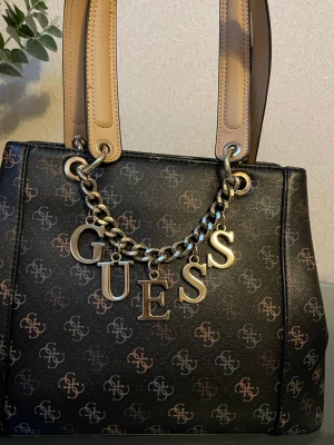 Väska GUEES lite använd - Säljer min väska som advents lite. H  25 cm B 15 cm  H på handtag 24 cm