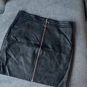 Skinnkjol - Svart skinnkjol med dragkedja. Stl L men tycker att det är en M