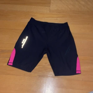Tränings cykelbyxor - Cykelbyxor med mindre reflexer En bakficka Med rosa på yttersidorna av varje ben Jättebra skick Material: 88% Polyester 12% Spandex