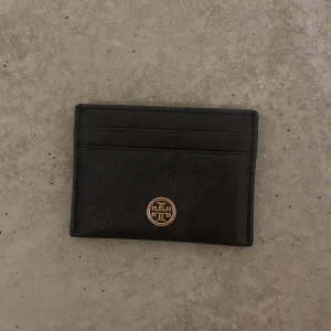 Tory burch korthållare  - Säljer min Tory Burch korthållare då jag köpt en ny. Haft i två år och är köpt på Raglady på väla. Har ej kvitto🤍
