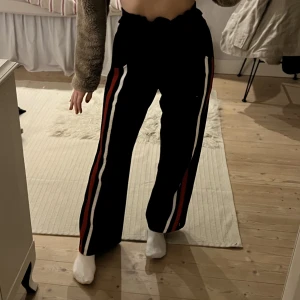 Mjukisbyxor - Svarta mjukisbyxor med färgade ränder på sidan och raka ben🤗Storlek S/M men eftersom de är justerbara i midjan så funkar de även för mindre storlekar💖