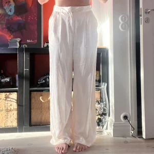 Satin kostymbyxa - Satin byxa i en benvit färg, off-white. Är lite stor i storleken, jag är 172cm lång. Aldrig använda. Perfekta till studenten. 