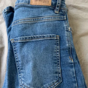 Gina Tricot - Jätte fina jeans blåa utsvängda jeans med slits. Säljer pga att dom e för korta i långden.