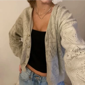 Grå kofta - Grå kofta som är stickad i ett fint mönster med guldiga knappar. Lappar om storlek och märke saknas men skulle säga att den är en xs. Pris kan diskuteras 