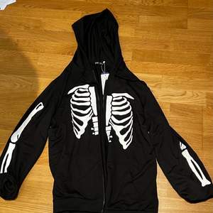 En svart hoodie med skelett tryck, aldrig andvänt 