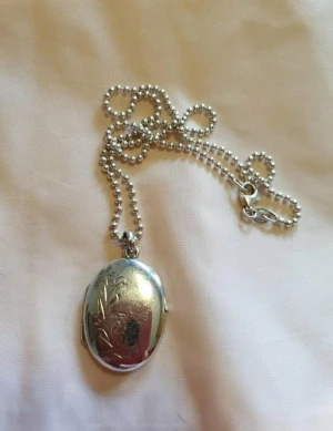 Äkta silvermedaljong  - Vacker medaljon för foton i äkta silver.Kulkedjan är äkta silver med.Längd 39 cm 