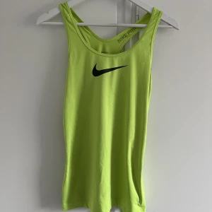 Nike träningslinne - Snyggt neonfärgat träningslinne från Nike, stl.M. Tyvärr kommer det inte till användning. Använt 2 gånger.