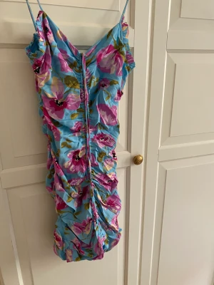 Blommig klänning - Blommig kort klänning från zara. Aldrig använd, proslapp kvar. Justerbar i längd. Dragkedja bak