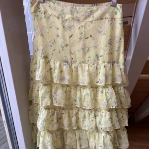 Gul blommig kjol från Gina Tricot - Jättefin gul, lite volangig kjol från Gina Tricot. Endast använd ett fåtal gånger. Strl 34