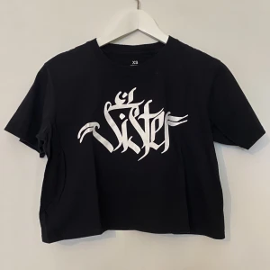 Hannah Pixie Snowdon T-shirt  - Hannah Pixie Snowdon T-shirt   Svart med trycket Sister  Croppad modell   Använd en eller två gånger så i perfekt skick 