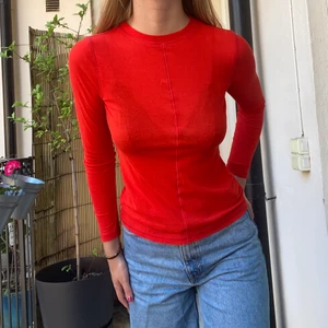 Orange tröja - Orange långärmad tröja med söm fram och på ryggen.