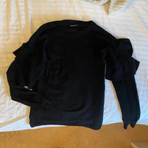 Svart stickad tröja med volang💓 - Säljer min mammas gamla stickade tröja med ett volang mönster på armen. Den är köpt på Gina för några år sen🥰⚡️skriv för frågor.