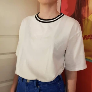 Vit t-shirt - Basic vit tshirt med svarta detaljer i halsringningen. Den har ingen storlek, men skulle nog passa XS-M/L. Den är stor i ärmarna men lite tightare nertill.