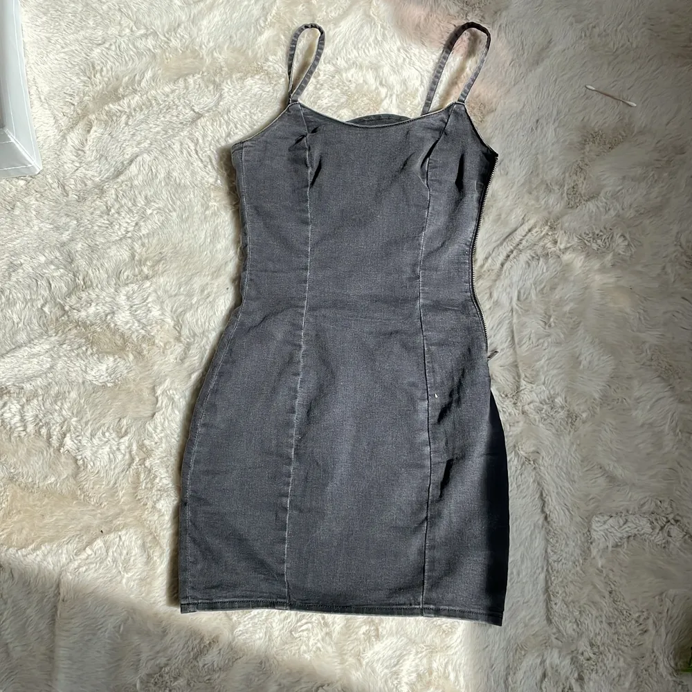 En tajt mörkgrå/svart klänning från hm i strl 36, ganska tunnt och stretchigt material. Klänningar.