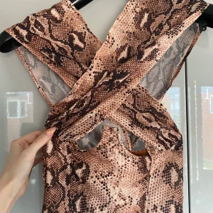 Topp - Söt topp med ormskinnsmönster från Pretty little thing, fortfarande med lapp kvar. Svårt att visa på bild men den är korsad upptill