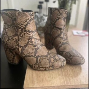 Hm och humana  - Ett par klackar i fejk ormskinn, köpta på skopunkten för några år sedan. Säljer för 50 kr. Använda en gång. Strl 37/4 Ett par korta cowboy stövlar köpta på Humana för några månader sedan. Använda en gång, vintage. Strl 37/4 Säljer för 200 kr