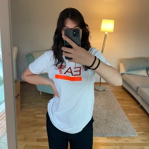 T-shirt  - T-shirt från Armani, knappt använd! Något oversized. Svårt att tyda på bilden, men i den orangea linjen står det emporio Armani. 