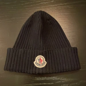 Moncler mössa.  - Säljer min moncler mössa som är köpt för ett halvt år sedan, den är snålt använd. Skick 9/10. Kvitto finns med!