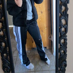 Adidas byxor - Fina byxor från adidas som är använda vid få tillfällen, toppskick!! Lite långa på mig som är 162, men går att vika ner i midjan så blir de lite kortare! Knappar längs hela benen som går att knäppa upp💕 nypris:799 så direkt pris är 300💓💓💓