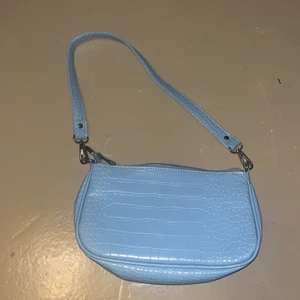 Blå väska - Väska från Gina tricot. Väldigt använd men syns inte om man inte kollar noga noga på insidan. Vacker blå färg och perfekt till klänning. Pris går alltid att diskutera vid snabb affär. Va 