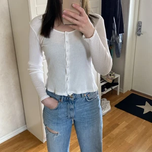 Vit långärmad tröja storlek M - Vit ribbad tröja från Nelly storlek M. Materialet är tunt och aningen genomskinligt, skulle rekommendera att ha ett linne under. 