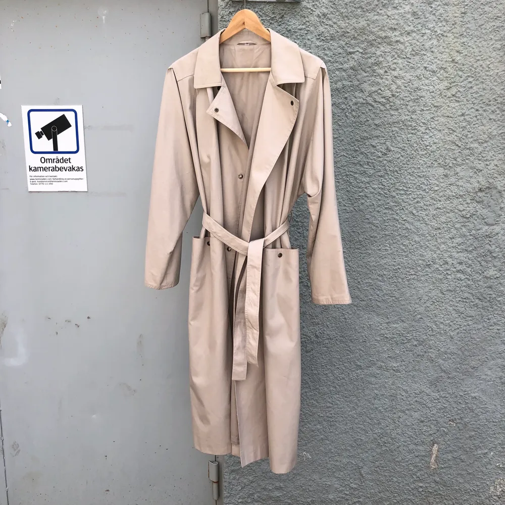 Beige trenchcoat med äldre h&m-lable. Märkt storlek C42, sitter lagom oversized på mig som normalt bär storlek S/36 i kläder. Handsydda stygn i fodret i axlarna som om det tagits bort axelvaddar av tidigare ägare. 35% bomull 65% polyester. Swish is queen🧥. Jackor.