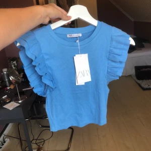 Linne med volang - Mellan blå linne med volang från zara i storlek S aldrig använt. 