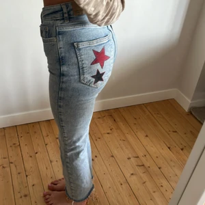 Jeans med tryck - Supercoola jeans från Gina tricot. Dom är lätt utsvängda längs ner och har ett tryck med två stjärnor på ena fickan. Köpta för ett år sedan och är i mycket bra skick. ❤️