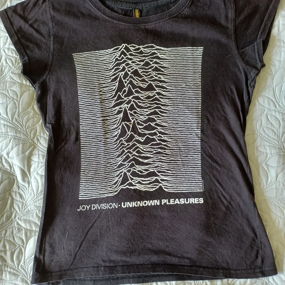 En Joy Division T-shirt med bilden från albumet Unknown Pleasures.  Det står på lappen att t-shirten är i storkel M men jag skulle mer säga att det är i storlek S. ~ Varan kostar 50 kr och frakten kostar 39 kr.. T-shirts.