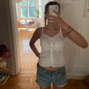 BikBok vit spets topp - Säljer denna urgulliga vita spets toppen ifrån en gammal kollektion från bikbok! Jag verkligen älskar den, men den kommer tyvärr inte till så mycket användning. Banden är justerbara. Obs! sömmarna har gått uppe lite på vissa ställen, men inte så märkbart!