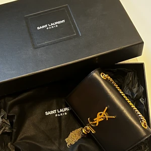 Ysl väska - Hej, jag säljer nu min ysl väska i modell ”KATE SMALL CHAIN BAG WITH TASSEL IN GRAIN DE POUDRE LEATHER”. Från år 2018, nypris 19 000 och den är i använd skick men fortfarande fin🩷Box, dustbag och äktenhetsbevis finns.🤍